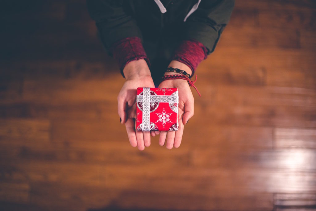 two extended hands holding gift